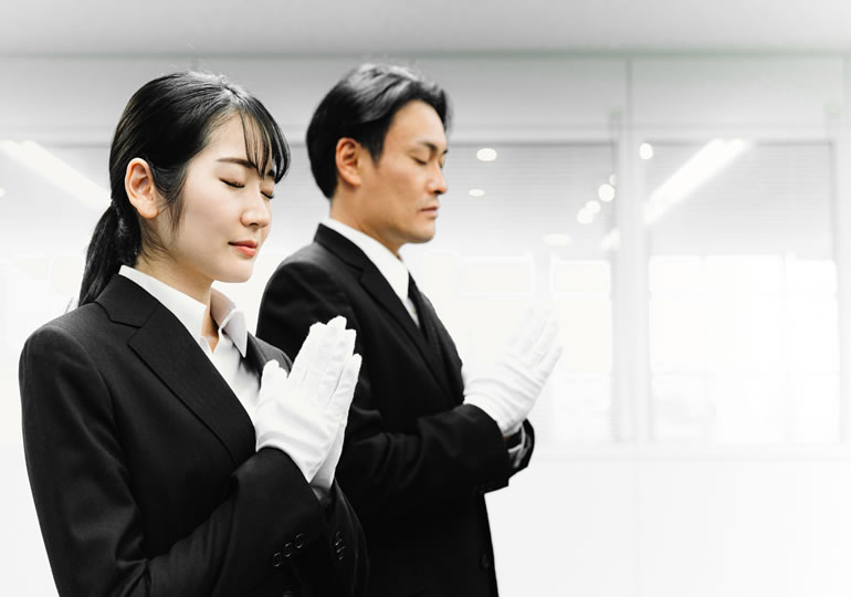 火葬場で合掌する火葬場職員
