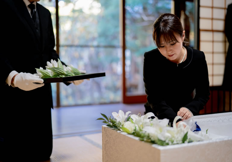 納棺花入れの儀をする女性