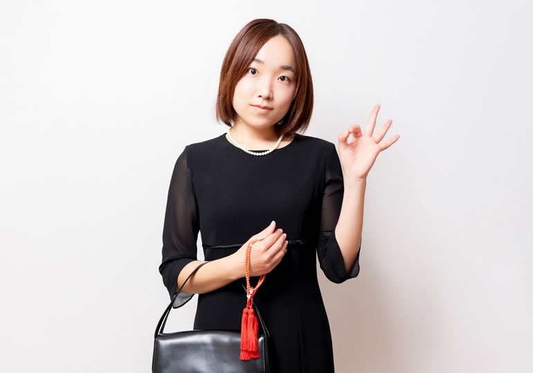 喪服姿で墓じまいの費用に納得する女性