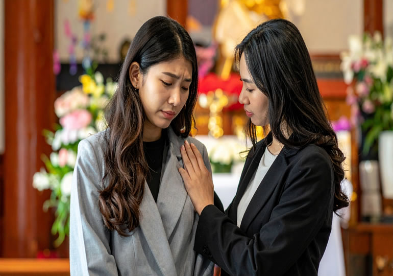 葬式で悲しむ姉妹