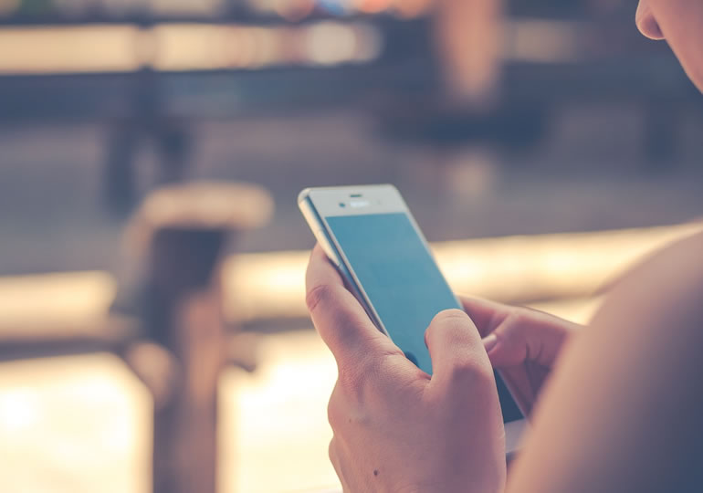 散骨の依頼をスマホで調べる外国人女性