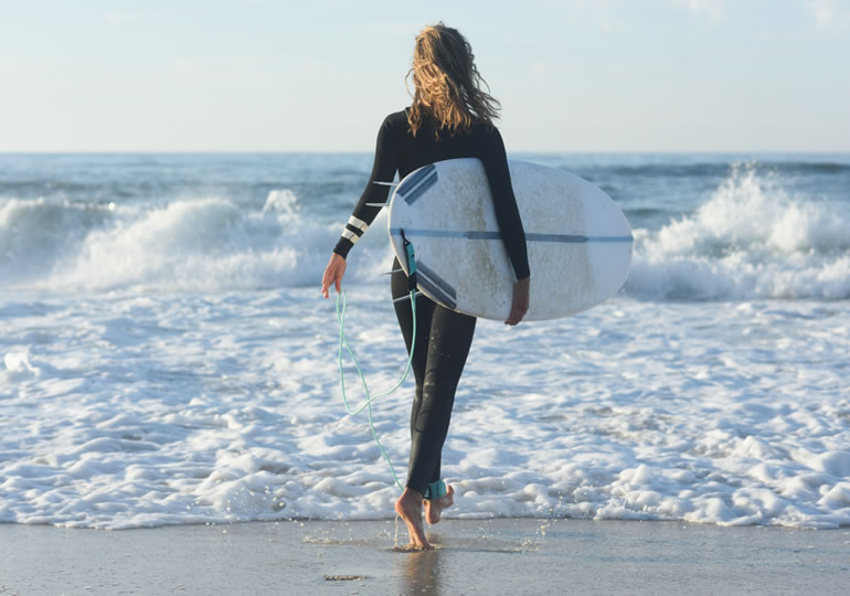 海洋散骨した海でサーフィンをする女性