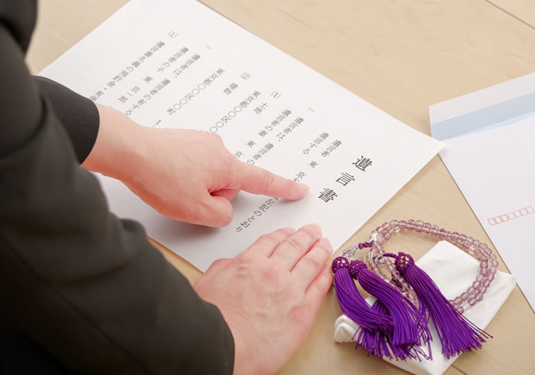 葬儀会場で遺言書を指さす女性のイメージ画像