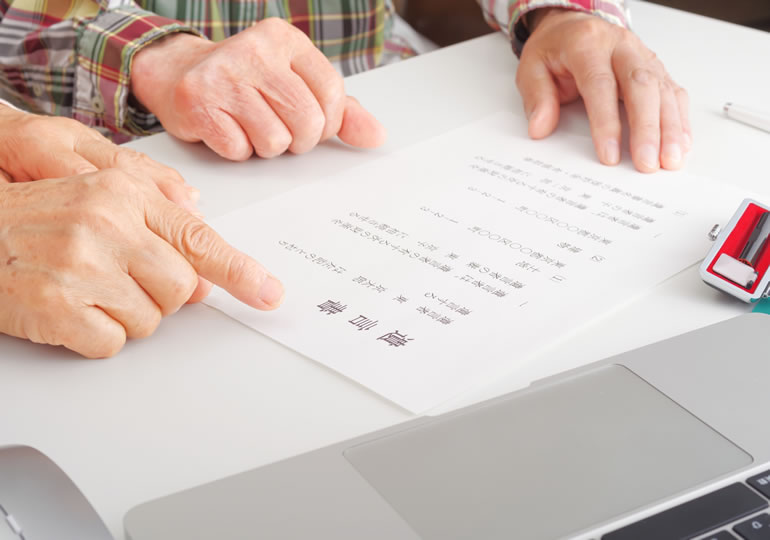 遺言書を指さして会話する老夫婦